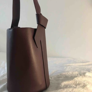  - Axelväska i lila/brunfärg, sparsamt använd!  Frakt tillkommer/hämtas upp i Sthlm 