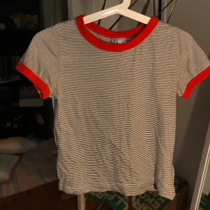 Randig T-shirt  - Randig tröja från hm med röda kanter. Storlek XS. Använd ett fåtal gånger och i fint skick. Frakt tillkommer 