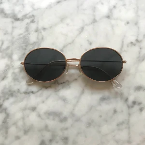 Solglasögon, ovala (från min profilbild) - Solglasögon i fint skick, köpta från Asos. Oval 90-talsmodell. 50 kronor inkl. frakt. 