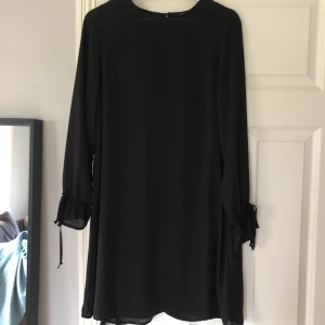 Svart fin klänning strl 34 - Svart fin klänning från Gina Tricot i storlek 34. Har knyte vid ärmslutet. Tunt fint material. Perfekt till jul o nyår! 