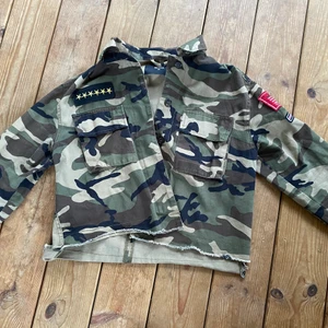 Militärjacka  - En cool croppad oversized militär jacka ifrån BikBok i storleken XS. Jackan är välanvänd men ser forfarande bra ut och har inga slitningar. Den har 3 stycken militär liknande detaljer. 