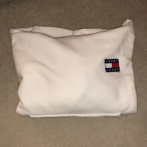 Tommy Hilfiger hoodie vit XXS - Säljer en Tommy Hilfiger hoodie, färg vit, storlek XXS, använd 1 gång, modellen är lite croppad, köpt via Boozt. Säljer då den är för liten för mig.