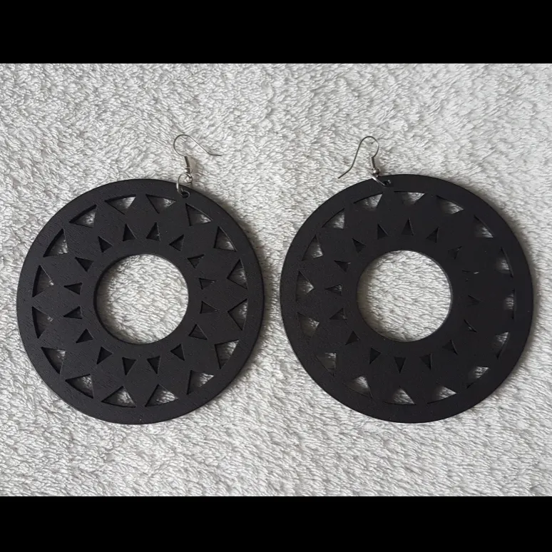 Ett par estetiska svarta örhängen. Beskrivning: Lätta, runda, svarta, solros 🌻 örhängen. 9cm i diameter.  Oanvända. Frakt tillkommer med 24 kr.. Accessoarer.