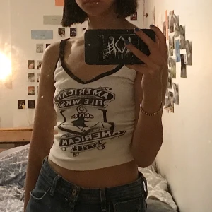 Linne från only - Ett vitt linne med svart tryck och svarta ”scrunchade” axelband och detaljer runt halsringningen. Scruncat mellan brösten. Trycket lite slitet men det är själva charmen enligt mig.  Ingen storlek angiven men uppskattar till xs. Även passa xxs-s. 