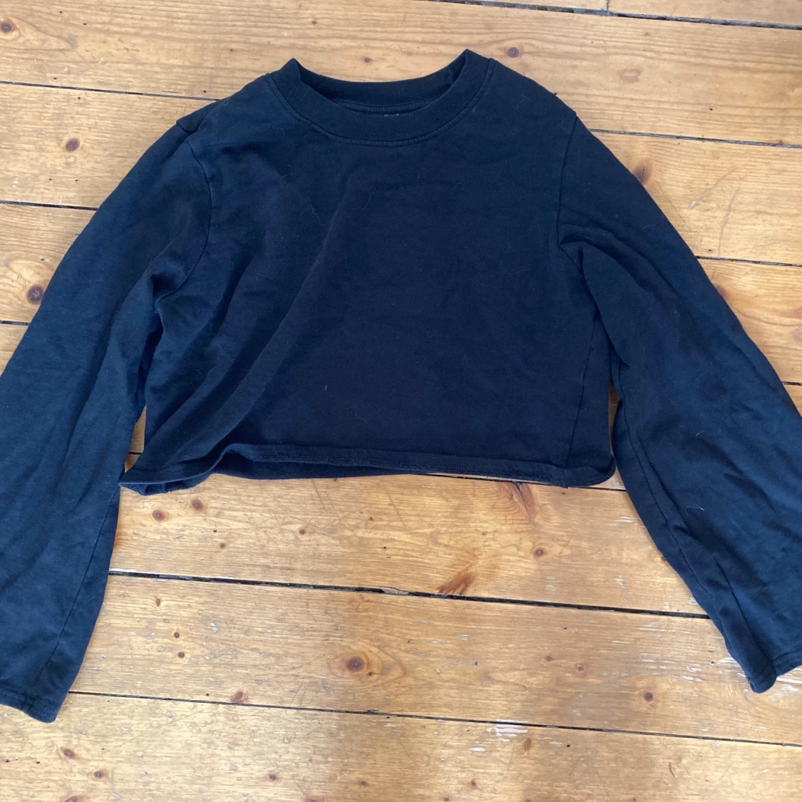 svart tröja med utsvängda armar