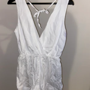 Vit playsuit - Supergullig vit playsuit, från någon butik i Spanien. Det står ingen storlek men passar mig som brukar storlek S, och är 160cm lång. Ser givetvis bättre ut när den är struken. 