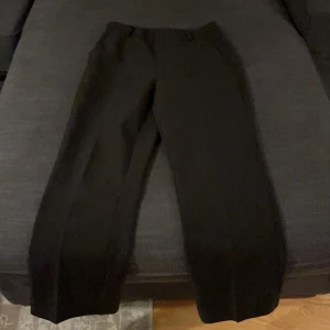 Svarta ankle kostymbyxor - Svarta kostymbyxor som går till anklarna. Kan ej ta kort på för dom passar inte längre , frakt ingår.