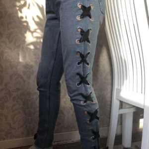 Coola monki jeans strl 26 - Coola jeans från monki med snörning! De är i mom-jeans modell och styva i materialet. Använda men i fint skick, däremot är en av hällorna lite lös, det är inget som märks men kan skicka bild på det vid intresse. Innerbenslängden är ca 73 cm. Köparen står för frakt✨