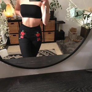 Jeans  - Fina svarta tigta byxor med rosor på, dragkedja på sidan av höften, jag är S och de sitter väldigt tight på mig så skulle tro de passa perfekt på nån som är XS💞 skriv för frågor eller fler bilder💗