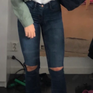 Blåa jeans med hål - Blåa bootcut jeans med egen klipporna hål (ser bättre ut ån på bilden), sitter snyggt på och är i bra skick. Skulle säga att de passar någon som är kortare än 170 ungefär. Köpare står för frakt!