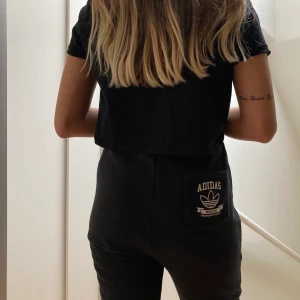 Adidas byxor med tryck - Byxor från Adidas med tryck framtill samt logga på bakfickan. Strl S (36) i toppskick. Mjukt material utan stretch. 