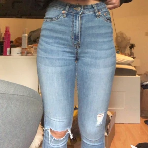Lager 157 - Blåa jeans med hål på ena knät och slitning på andra, från lager 157, är i nästan nytt skick, använt ca 4 gånger, dem är i storlek XS men passar även S