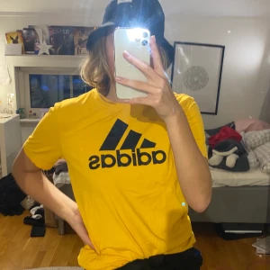 Gul Adidast-shirt - Färgstark t-shirt som går att använda både till träning och till vardags. Använd 1 gång. Står inte storlek, men är i min size och jag är 175 cm lång och är small/medium.