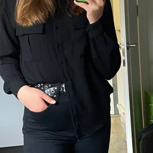 Svart Skjorta - Alla knappar sitter kvar och det är Inge som är lös eller så