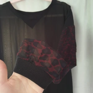  - Svincool meshtröja med vinröda leopardmönstrade ärmar. Märkt med 42 men sitter snyggt löst på mig med M, passar både mindre och större beroende på hur man vill det ska sitta! Använd 1 gång bah, skandal, förtjänar ett hem där den blir använd mkt mer !