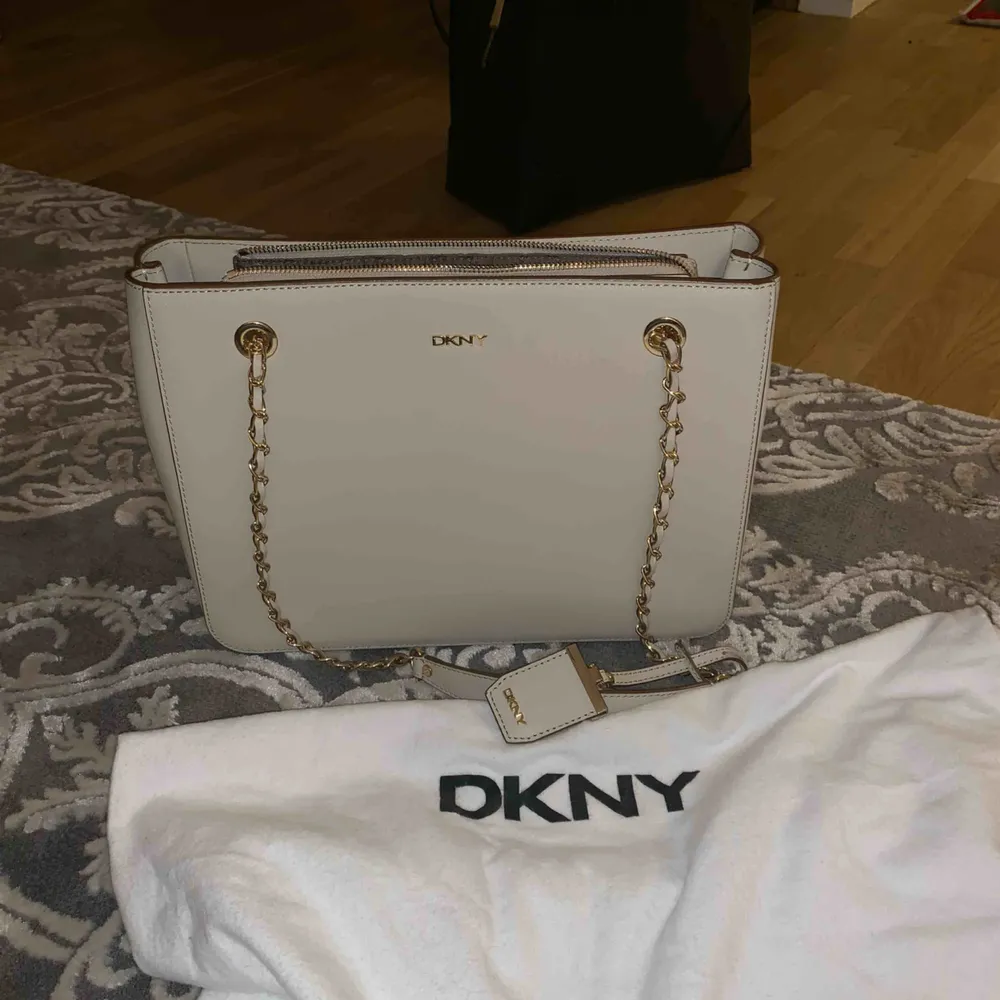 Säljer denna äkta DKNY-väska med gulddetaljer p.g.a. har alldeles för många väskor. Väskan är i väldigt fint skick, enbart använd vid två tillfällen. Ej prutbart pris. Möts upp i centrala Göteborg, annars får köparen stå för frakten (skickar spårbart).. Väskor.