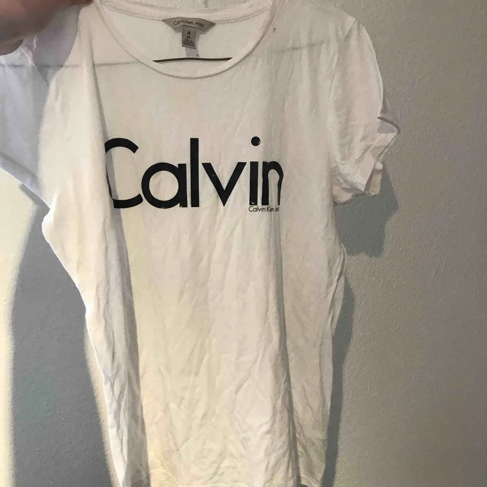 Jättefin Calvin Klein tröja i vitt, trycket är i svart , Blank lite som latex byxors material . T-shirts.