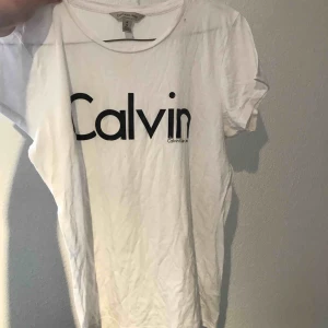  - Jättefin Calvin Klein tröja i vitt, trycket är i svart , Blank lite som latex byxors material 