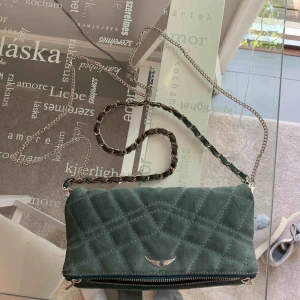  - En liten Zadig et Voltaire väska. Mocka i ljusblått. Finns inte i butik men är sliten så säljer för 400. Två axelband en kort och ett långt. Ena bandet är slitet (se bild 3) men inget som syns. 