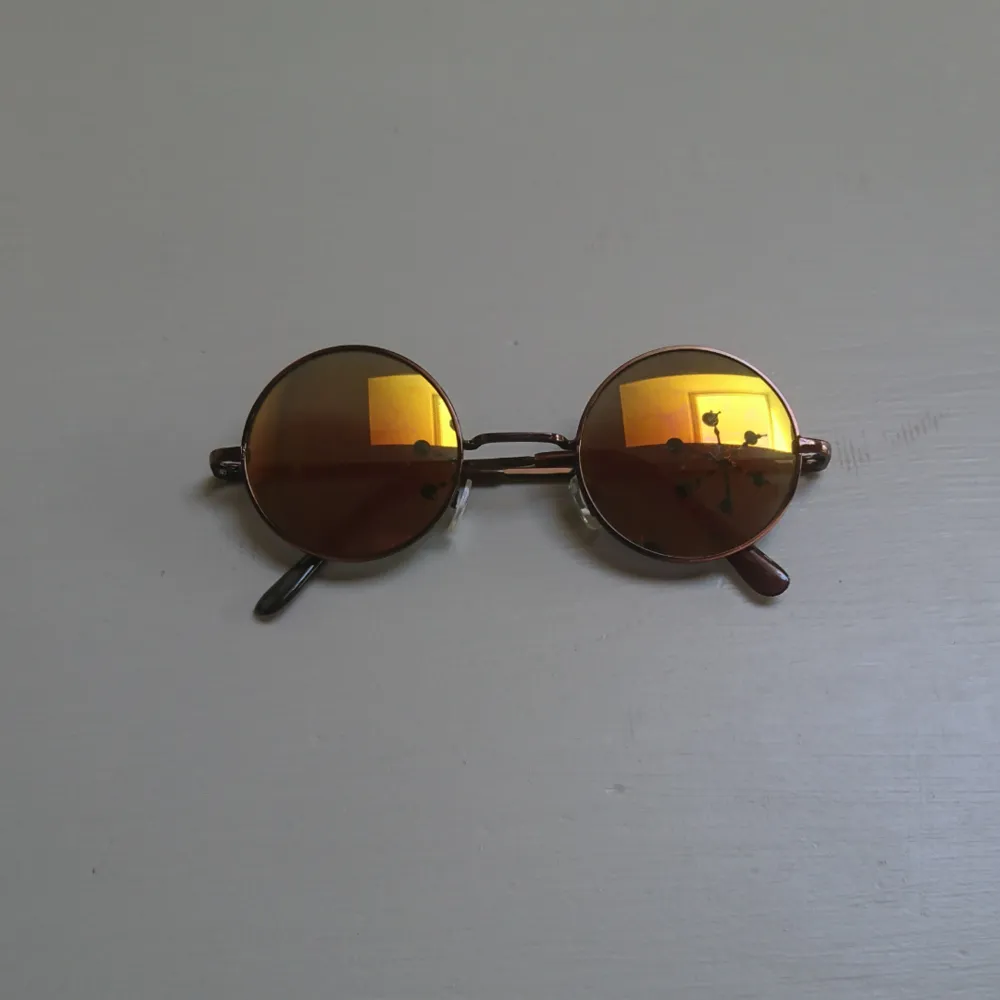 Runda solglasögon med gul/orange/grönt glas. . Accessoarer.