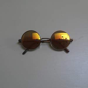 Runda solglasögon med gul/orange/grönt glas. 