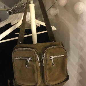  - Noella bag köpt här på plick! Kommer tyvärr ej till användning därför säljer jag. Långa bandet följer inte med och väskan har små slitningar på framsidan men ingenting man tänker på! Storlek M och militärgrön