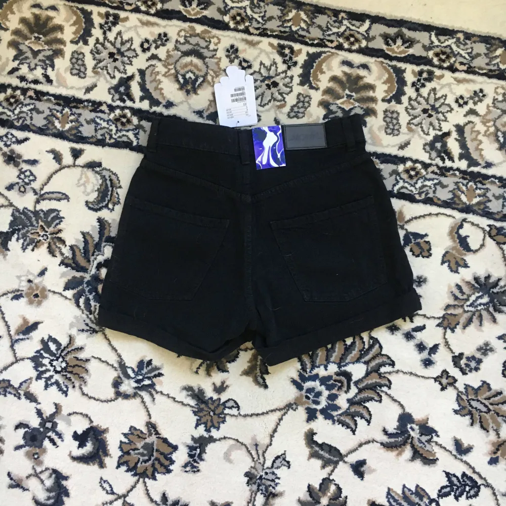 Svarta shorts med snygga slitningar på låren, från Monki i storlek xsmall. Höga i midjan. Aldrig använda.  Köparen står för ev frakt . Shorts.