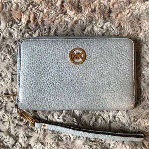  - Ljusblå med gulddetaljer. Nästan aldrig använd. Ursprungligt pris 1099kr  Finns mobilfack, sedelfack,myntfack och kortfack. Möts helst upp i stockholm, frakt tillkommer annars