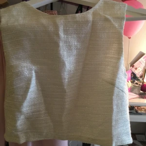  - Oanvänd fin croptop i vävt tyg i skimrande nyans. 