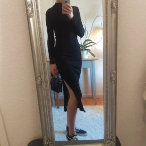  - Tight klänning i tjockt strechmaterial, dragkedjor på båda sidor som går halvvägs upp på låret. Storlek 36. Använd ett fåtal gånger. Frakt 45:-