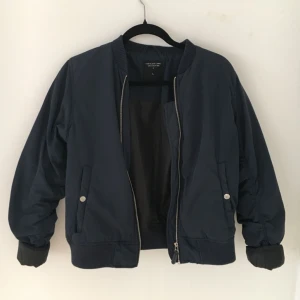  - Marinblå bomberjacka från Lager157. Jackan har en liten reva vid ena fickan, därav priset. Jag har i vanliga fall XS-S och denna sitter bra på mig (oversized), så jag skulle säga att den passar allt från XS-L beroende på hur man vill att den ska sitta. 