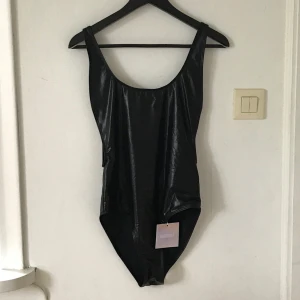  - Body i lack/skinn wet look glansigt material, helt ny 