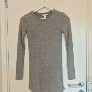  - Grå långärmad figursydd klänning i fint skick. Kan mötas upp i Stockholm eller skickas. 