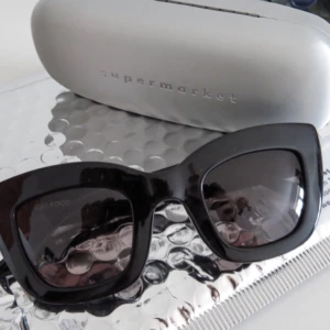  - Skitsnygga och helt oanvända solglasögon från märket Supermarket. Modellen heter catfood. Färgen är svart. Inköpta i somras för ca 900kr från deras hemsida thisissupermarket.com

Märket är svenskt och alla deras solglasögon är handgjorda.
Bredd 150mm, höjd 54mm, 
UV400. 

Solgalsögonen kommer skickas som ni ser på bild ett med sitt orginalfodral i det silvriga bubbelplastkuvertet som jag fick dem i. Så du får det exakt likadant som om du beställer nya från deras hemsida :) 

Den sista bilden är printad från deras hemsida.
