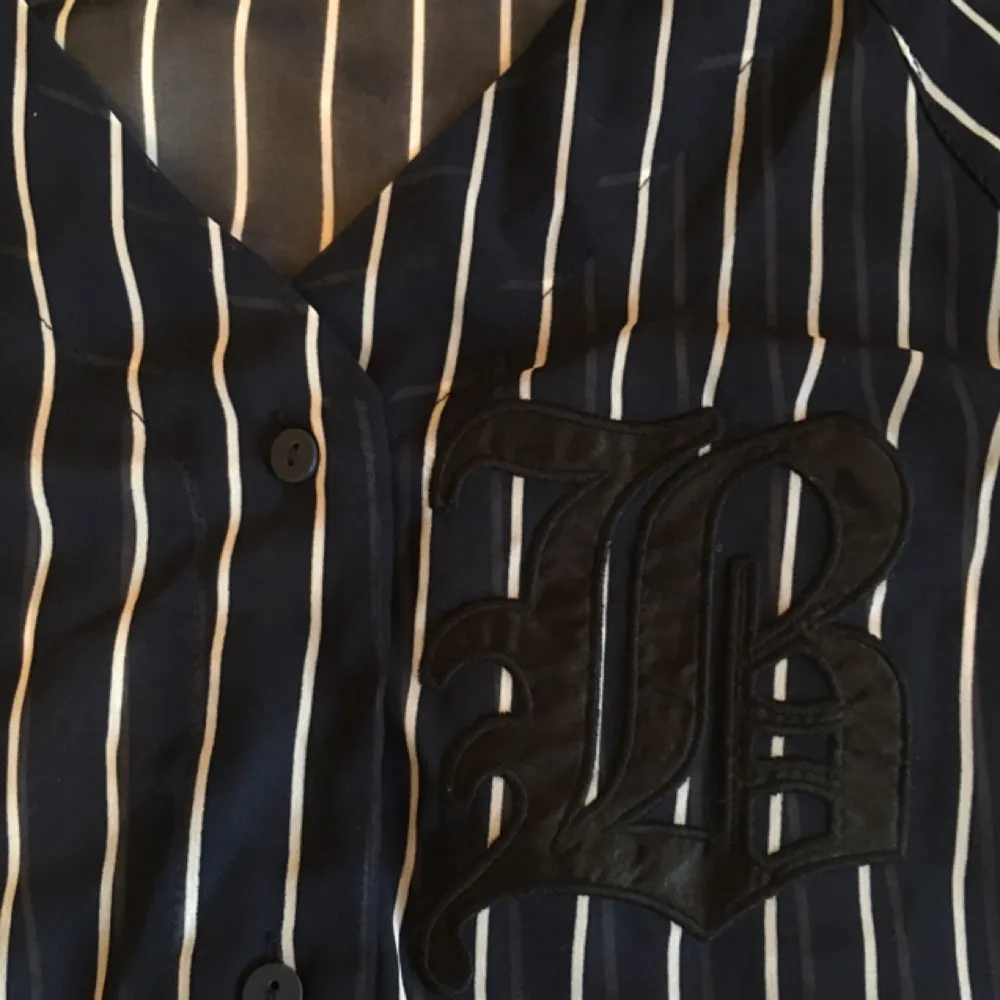 genomskinlig, baseball inspirerad blus! ser svart ut men är marinblå. knappt använd!. Blusar.