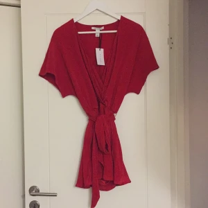  - Jumpsuit med band i midjan. Köparen betalar frakten.