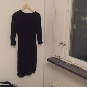  - Tight svart klänning med paljetter, lite lösa trådar här och var. Sitter snyggt på, 3/4-långa armar med dragkedja bak. Kan mötas upp i Göteborg eller skickas, då frakt tillkommer