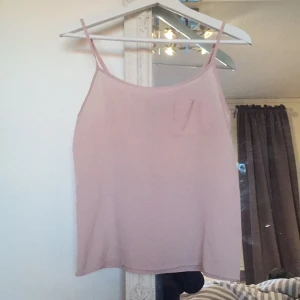  - Tunt ljusrosa linne men en ficka på ena bröstet. 