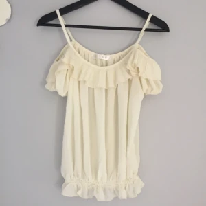  - "Off the shoulder" linne. Jag skulle säga att det är storlek XXS, alternativt en liten XS. Något genomskinlig.