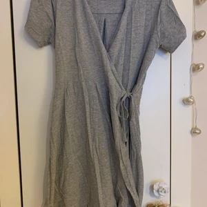 Grå omlottklänning.  - En söt grå omlottklänning i strl 158-167 i barn, men passar en lite kortare xs, typ 160 och ner. Den är för kort för mig så jag använder inte den längre men den är jättesöt. Skriv för intresse och om ni vill ha fler bilder på den 💙