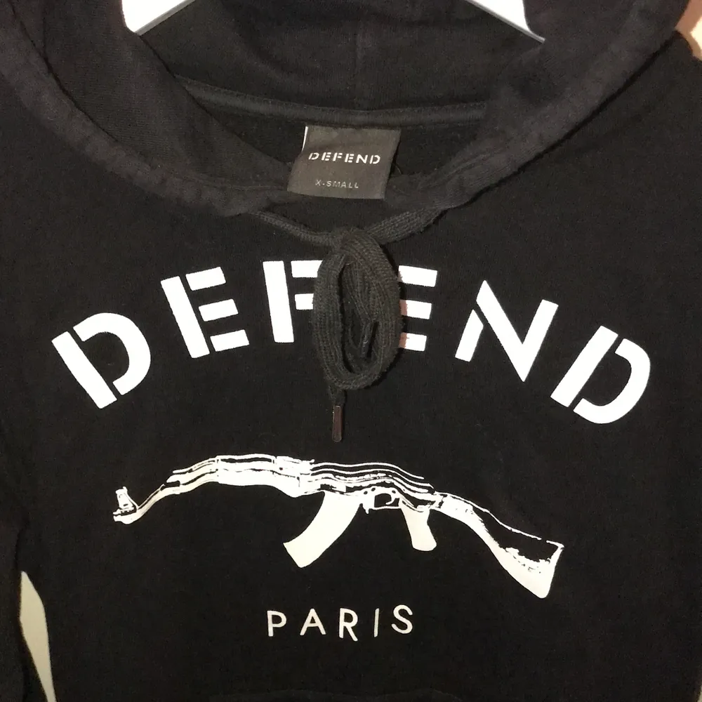 En snygg svart ”DEFEND PARIS” hoodie i storlek xs men passar xs/S  köpt för 899 kr och säljer den nu för 179kr💋 köparen står för frakt👌🏽🤩. Hoodies.