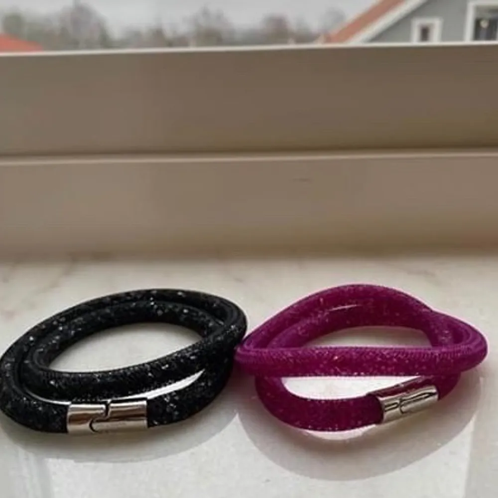 Säljer två stycken äkta swarovski crystal double wrap bracelet i helt nytt skick!  Ett är i en stark rosa och det andra är i svart, båda har ett fint glitter och ett spänne i en silverfärg                       220kr/st. Accessoarer.