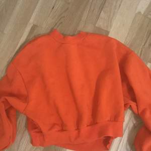 En orange hoodie från divide i storlek S