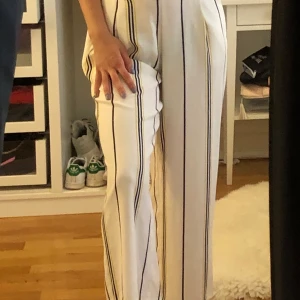 Byxor - Ett par finare randiga byxor, med en bra passform runt midjan och svarta knappar framtill. Ankellängd och väldigt sköna o fria vid benen. Är i ett mycket bra skick, använda ett fåtal gånger.