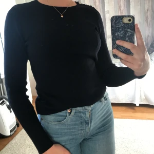 Ribbad långärmad T-Shirt från STOCKH LM - Ribbad mörkblå långärmad T-Shirt med silver knappar på höger axel från märket Stockholm. I fint skick och endast använd ett fåtal gånger, det finns alltså inga skador eller tecken på användning, är i princip som ny.