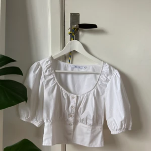 Vit topp - Topp från NA-KD. Köpt förra året och fortfarande i bra skick. Säljer pga blivit för liten för mig. Frakt tillkommer.