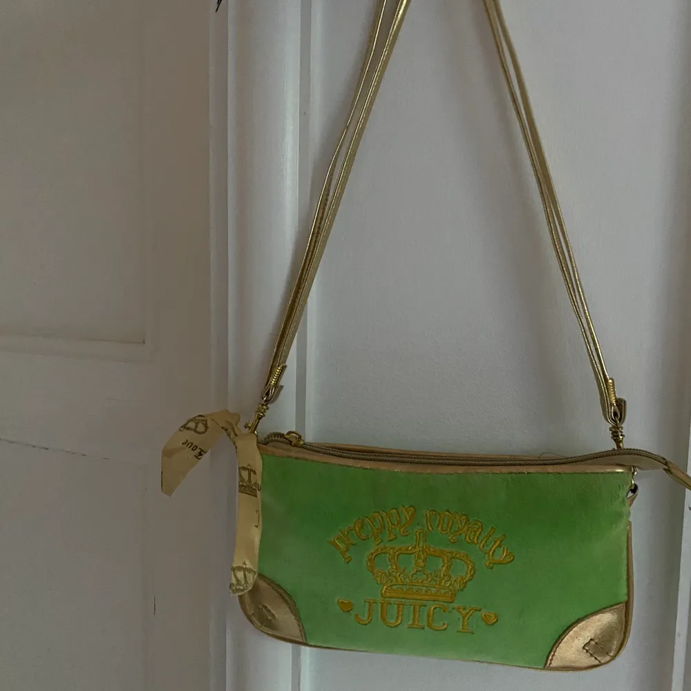 Grön och guldig handväska från juicy couture. Sparsamt använd och är i bra skick. Köpt secondhand.      Köparen står för frakt.. Väskor.