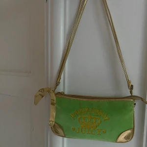 Lite Handväska från juicy couture - Grön och guldig handväska från juicy couture. Sparsamt använd och är i bra skick. Köpt secondhand.      Köparen står för frakt.