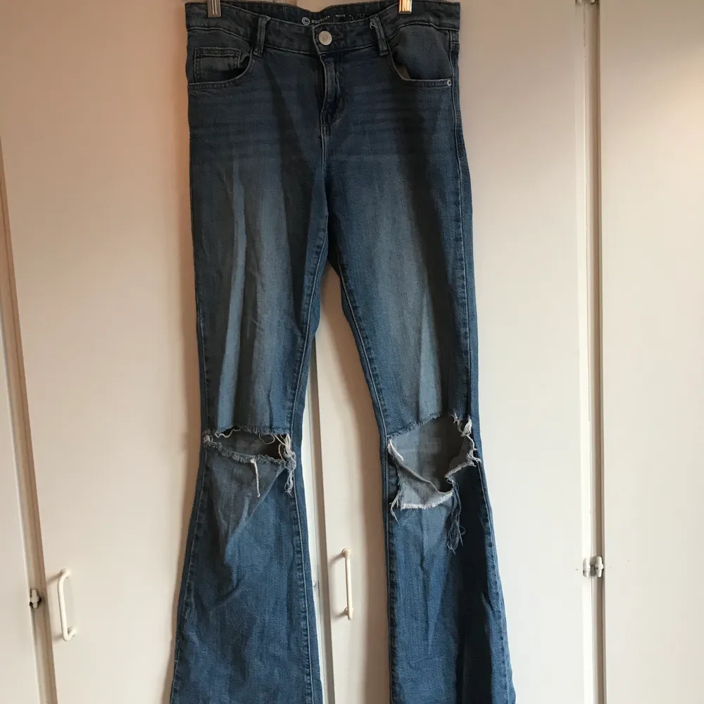 Bootcut jeans från Cubus med hål på knäna. Mellanblå färg i st 26/34, bra längd på mig som är 173. Köparen står för frakt. Jeans & Byxor.