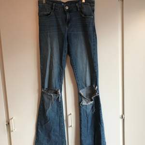Bootcut jeans från Cubus med hål på knäna. Mellanblå färg i st 26/34, bra längd på mig som är 173. Köparen står för frakt